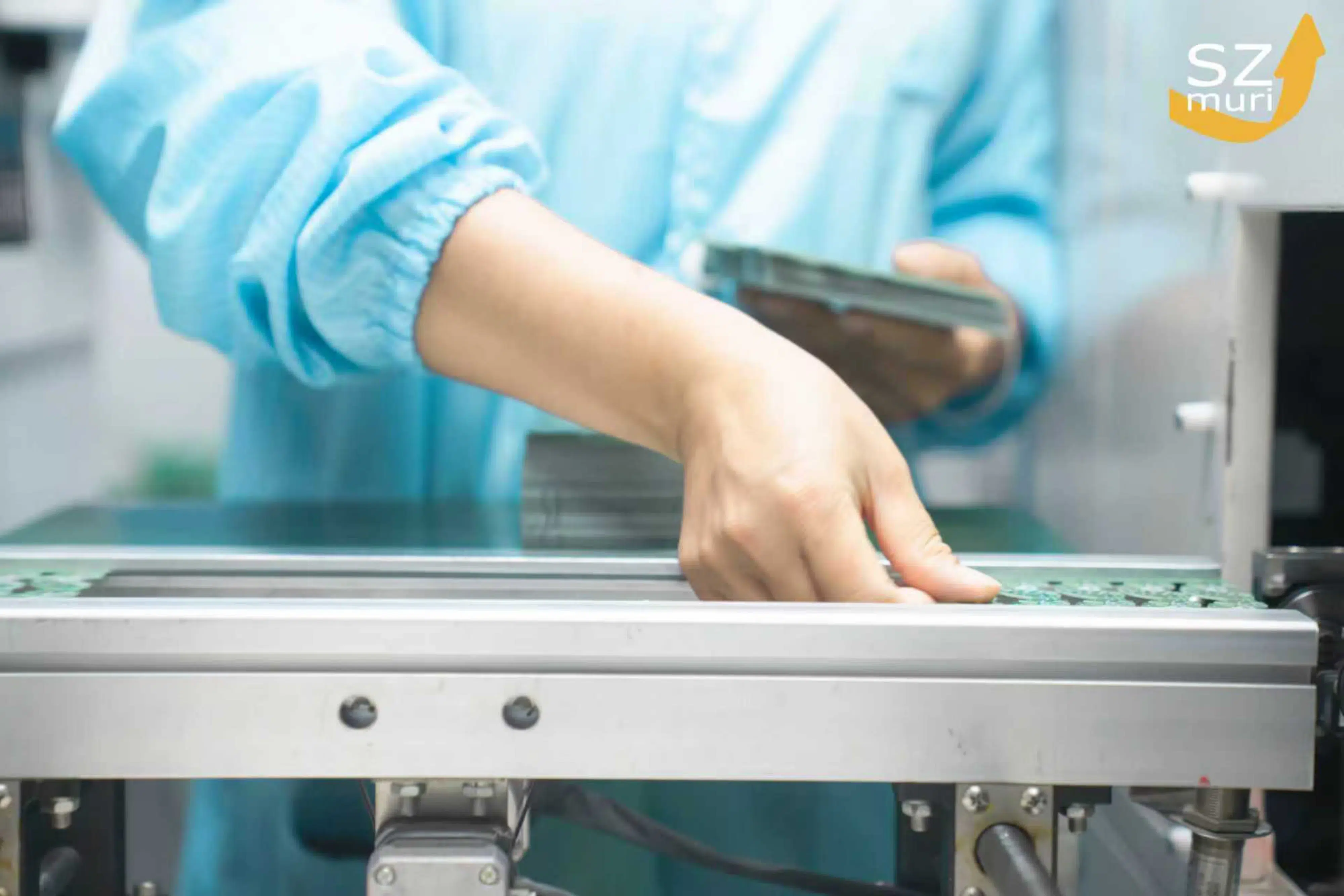 Eine Person in blauer Arbeitskleidung arbeitet konzentriert an einer Maschine