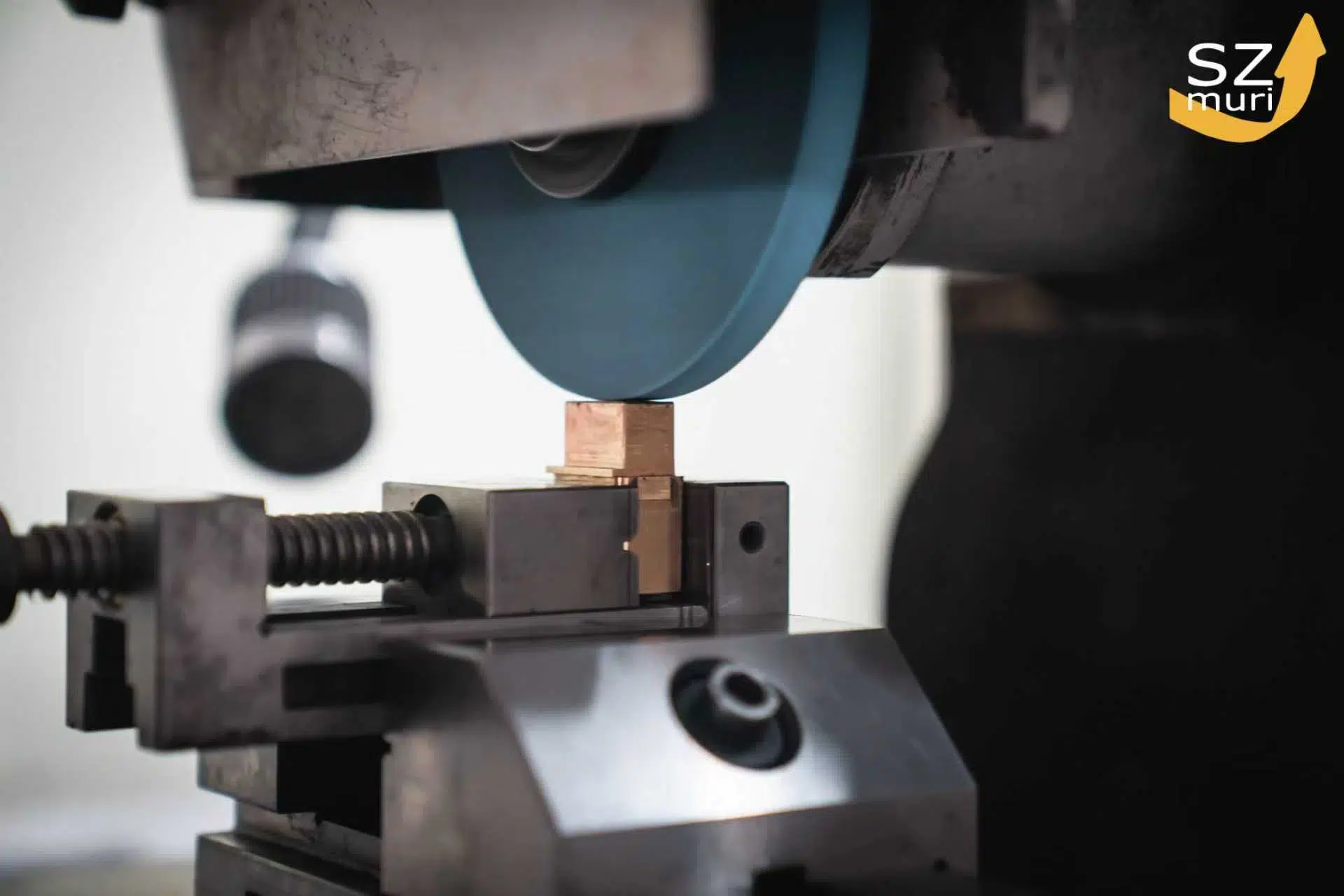 Eine silberne Metallsäge schneidet präzise einen kleinen goldenen Metallblock